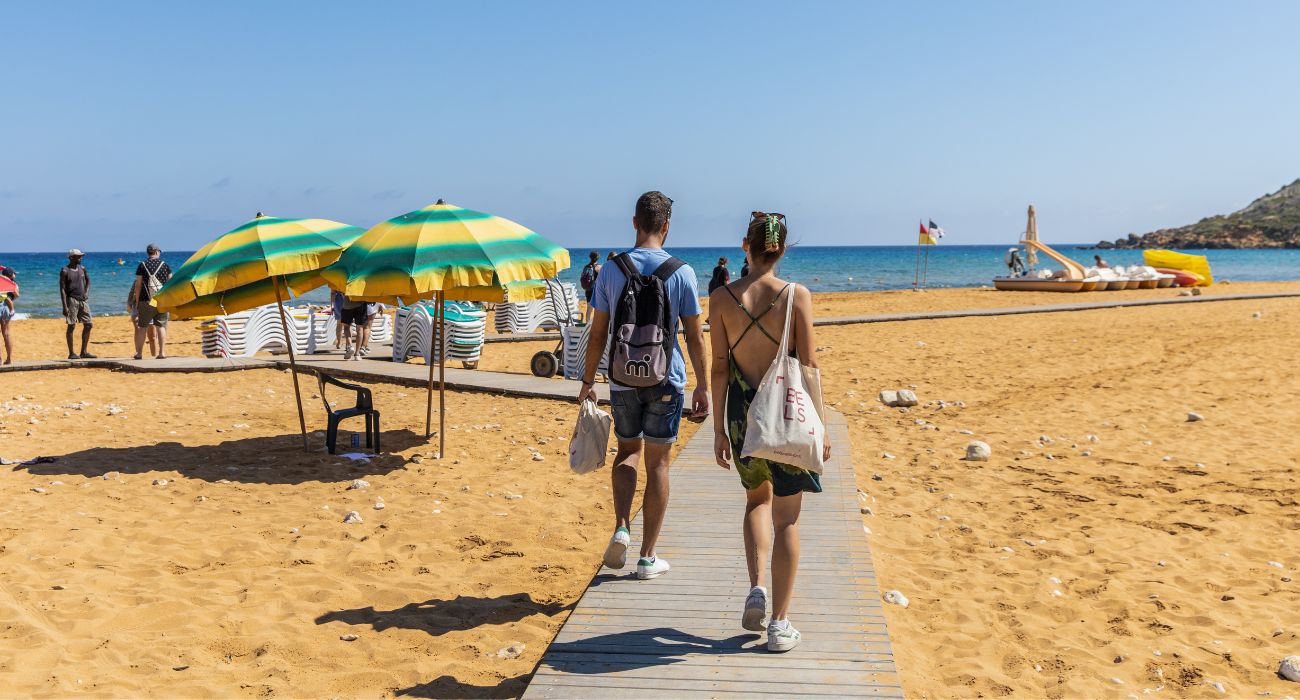 Zwei Schüler die am Strand Richtung Meer laufen